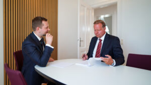 Jastram og Lund sidder ved et bord og gennemgår en bunke papir