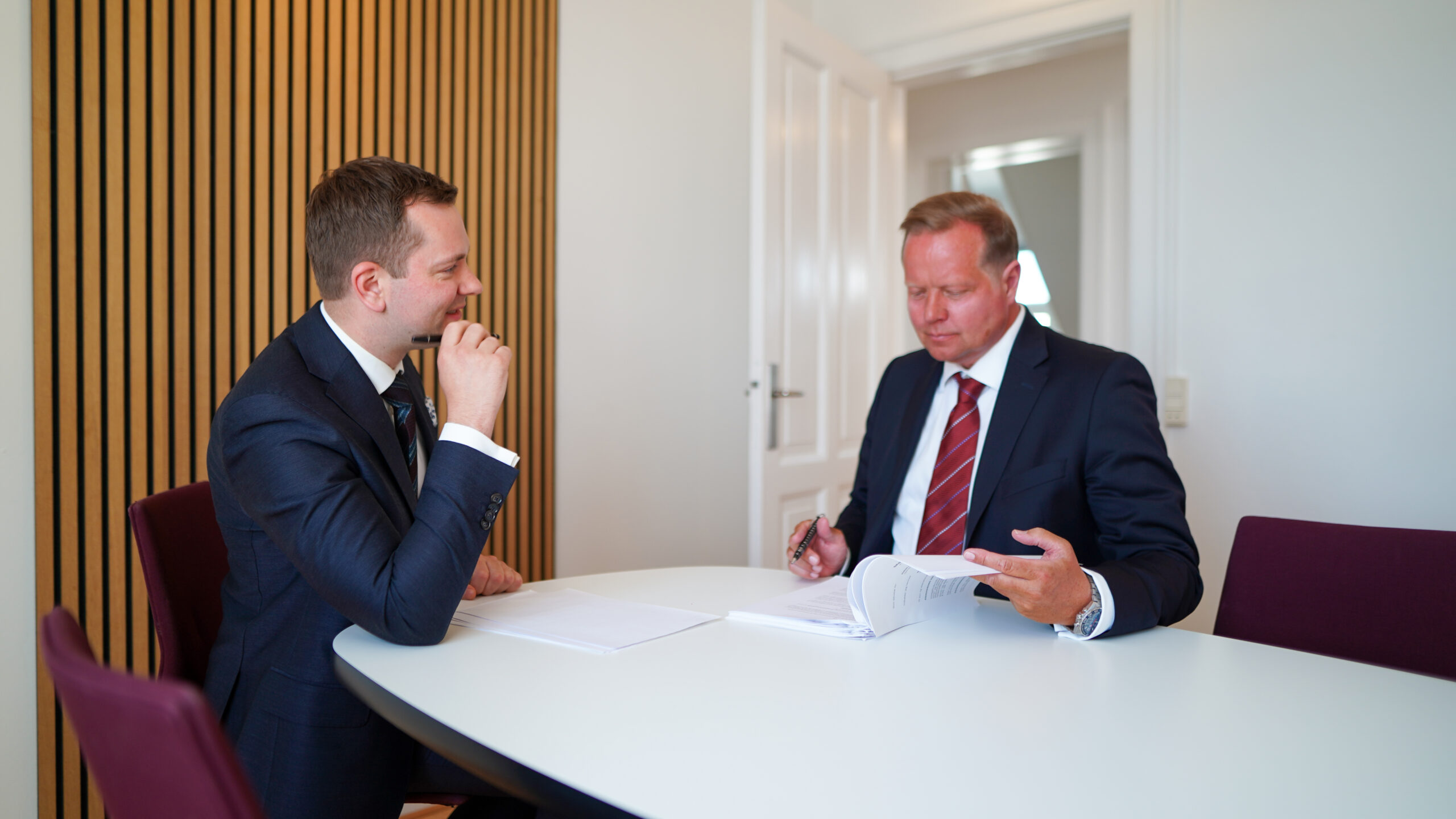 Jastram og Lund sidder ved et bord og gennemgår en bunke papir