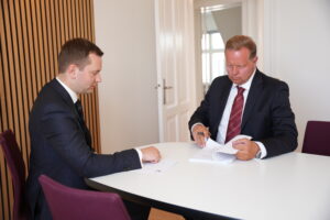 Jastram og Lund sidder ved et bord og ved at gennemgå en stor bunke papir