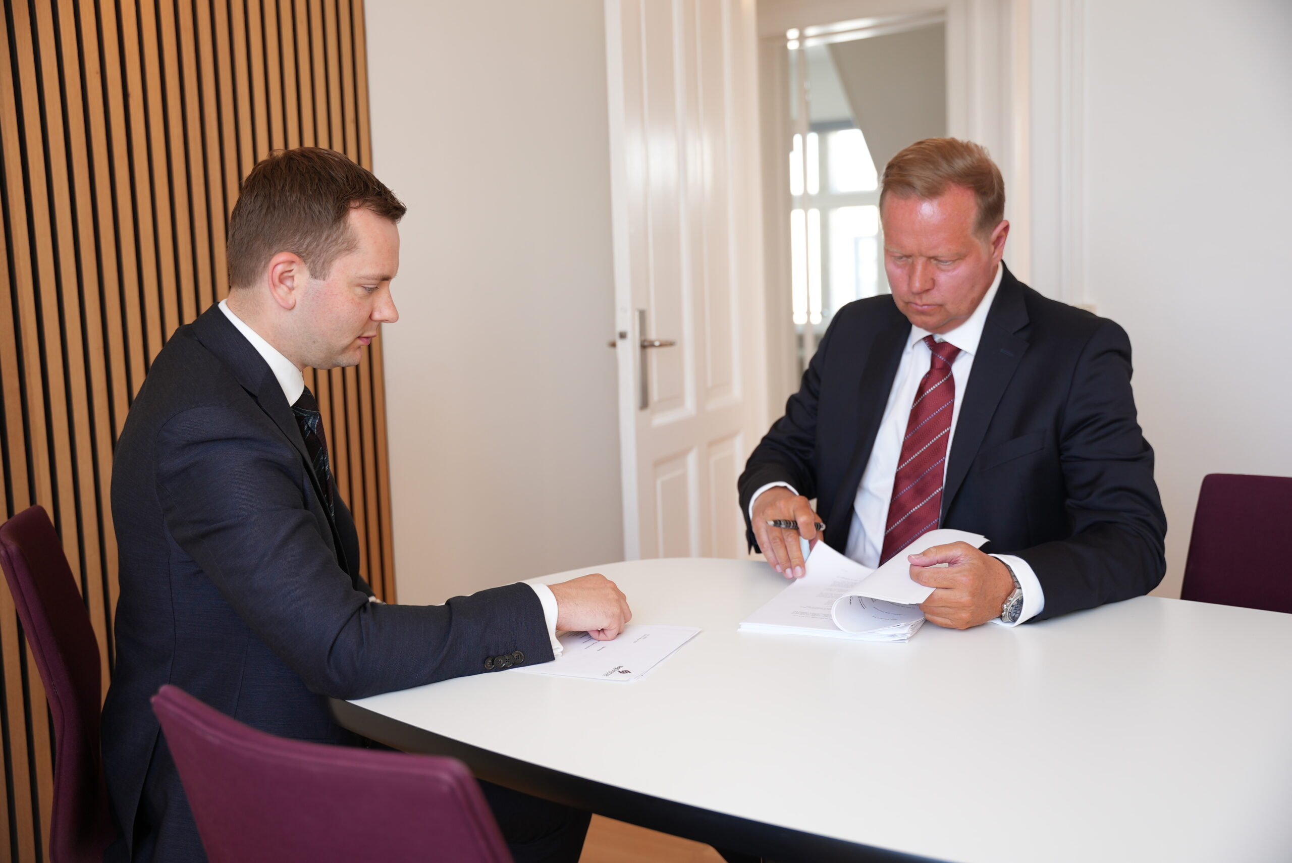Jastram og Lund sidder ved et bord og ved at gennemgå en stor bunke papir
