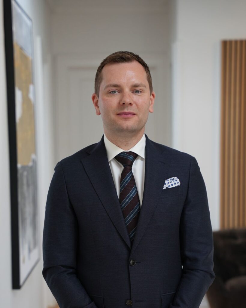 Nicklas Lund står i et jakkesæt og får taget profilbillede