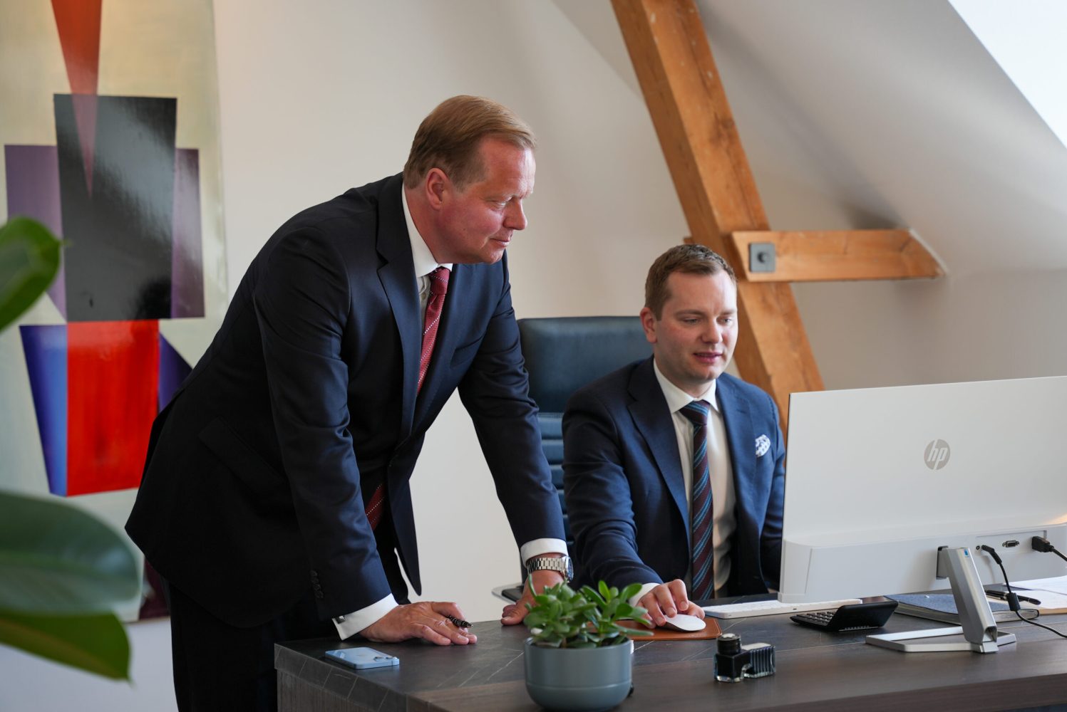 Nicklas Lund sidder ved en computer og ved siden af ham står Martin Jastram